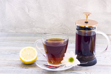 Siyah çay töreni - bardağın dolu çay, cam aranjman, çay yaprakları, şeker, sarı limon, bir ahşap kurulları zemin üzerine baharat. Üstten görünüm