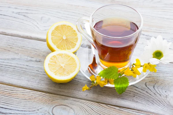 Siyah çay töreni - cam çay, çay yaprakları, şeker, sarı limon, tam bir ahşap kurulları zemin üzerine baharat. Üstten görünüm