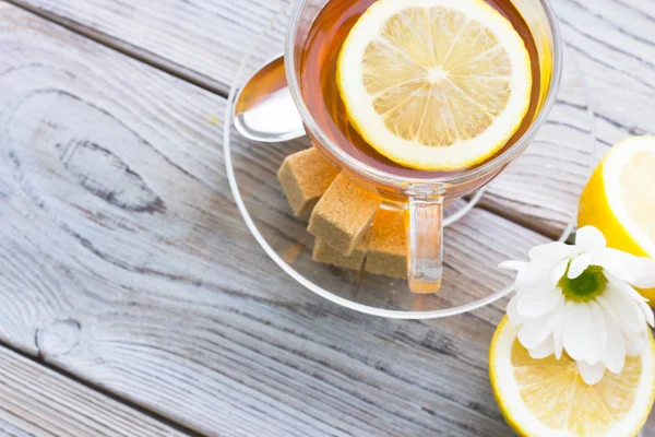 Siyah çay töreni - cam çay, çay yaprakları, şeker, sarı limon, tam bir ahşap kurulları zemin üzerine baharat. Üstten görünüm