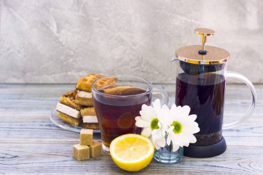 Siyah çay töreni - gözleme, cam tam çay, cam aranjman, çay yaprakları, şeker, sarı limon, çiçek, baharat ahşap Komiteler arka plan üzerinde. Üstten görünüm