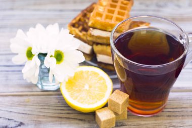 Siyah çay töreni - gözleme, cam tam çay, cam aranjman, çay yaprakları, şeker, sarı limon, çiçek, baharat ahşap Komiteler arka plan üzerinde. Üstten görünüm