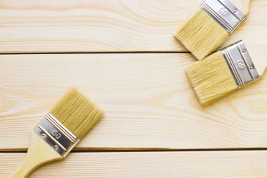 Ev yenileme kavramı, Derma boya fırçaları ahşap arka plan üzerinde görünümü top.
