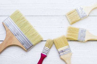 Ev yenileme kavramı, Derma boya fırçaları ahşap arka plan üzerinde görünümü top.