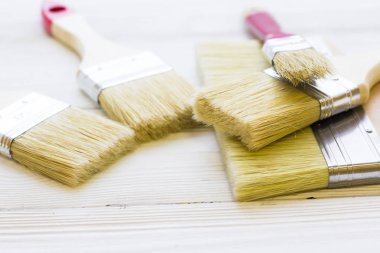 Ev yenileme kavramı, Derma boya fırçaları ahşap arka plan üzerinde görünümü top.