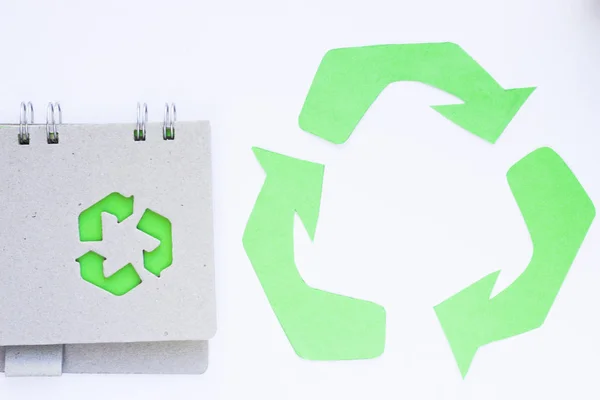 Environmental protection, ecology and recycling concept, recycle sign, notepad and garbage on white background top view closeup