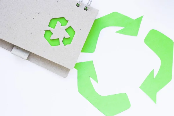 Environmental protection, ecology and recycling concept, recycle sign, notepad and garbage on white background top view closeup