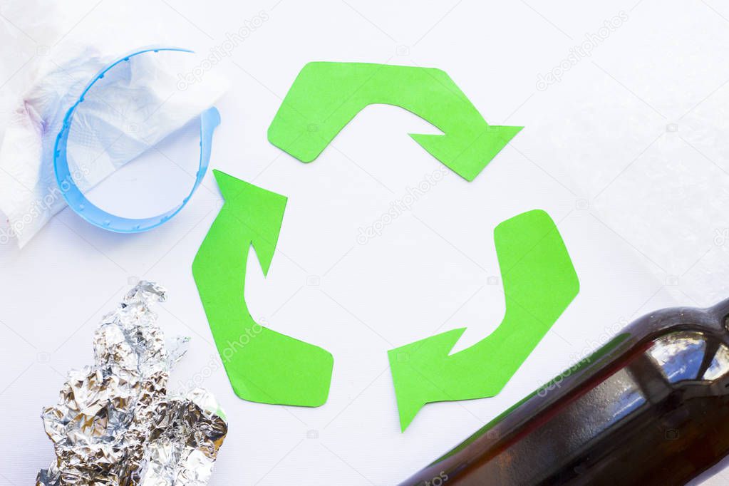 Environmental protection, ecology and recycling concept, recycle sign, notepad and garbage on white background top view closeup