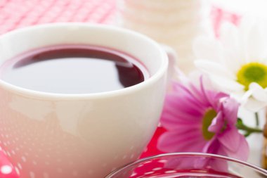 Siyah çay töreni - bir fincan çay, Çaydanlık, şeker, kek, beyaz noktalar arka plan, üstten görünüm, closeup ile kırmızı çiçekler