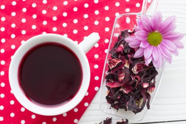 Siyah çay töreni - bir fincan çay, Çaydanlık, şeker, kek, beyaz noktalar arka plan, üstten görünüm, closeup ile kırmızı çiçekler