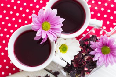 Siyah çay töreni - bir fincan çay, Çaydanlık, şeker, kek, beyaz noktalar arka plan, üstten görünüm, closeup ile kırmızı çiçekler