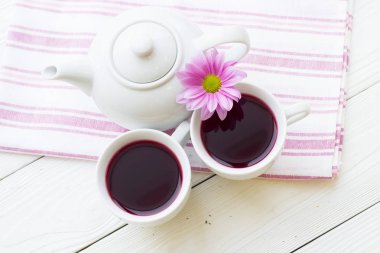 Siyah çay töreni - bir fincan çay, çaydanlık, şeker, kek, çiçekleri Beyaz ahşap rustik arka planda