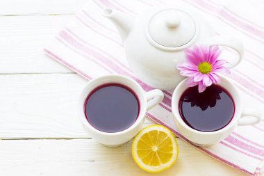 Siyah çay töreni - bir fincan çay, çaydanlık, şeker, kek, çiçekleri Beyaz ahşap rustik arka planda