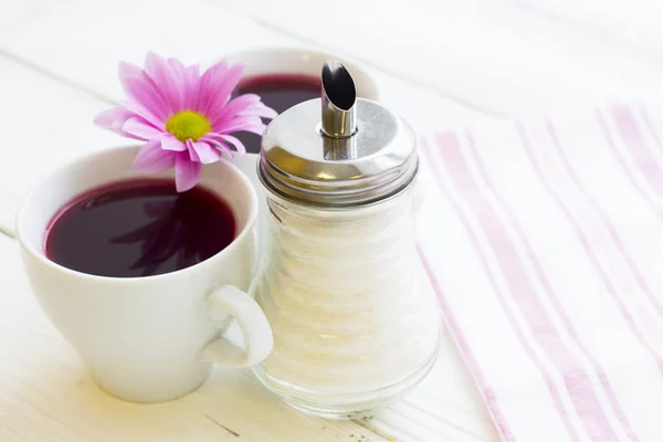 Чорна чайна церемонія чашка чаю, чайник, цукор, торти, квіти на білому дерев'яному сільському фоні — стокове фото