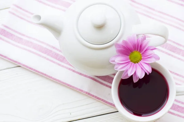 Zwarte theeceremonie - een kopje thee, theepot, suiker, gebak, bloemen op witte houten rustieke achtergrond — Stockfoto