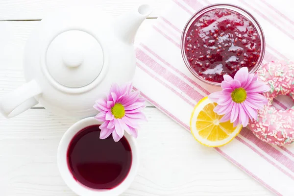 Schwarze Teezeremonie - eine Tasse Tee, Teekanne, Zucker, Kuchen, Blumen auf weißem Holz rustikalem Hintergrund — Stockfoto