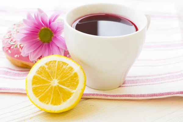 Schwarze Teezeremonie - eine Tasse Tee, Teekanne, Zucker, Kuchen, Blumen auf weißem Holz rustikalem Hintergrund — Stockfoto