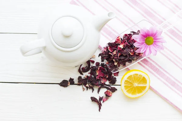 Schwarze Teezeremonie - eine Tasse Tee, Teekanne, Zucker, Kuchen, Blumen auf weißem Holz rustikalem Hintergrund — Stockfoto