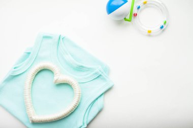 Yeni doğmuş bebek hikayesi. T-shirt ve çocuk oyuncakları, makas, bebek şişesi, meme, beyaz arka plan üzerinde saç fırçası