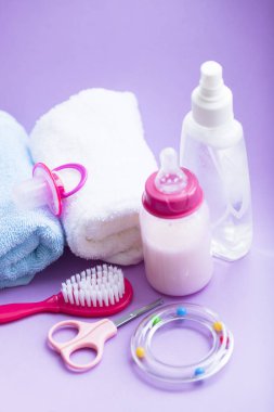 Yeni doğmuş bebek hikayesi. Havlu ve çocuk oyuncakları, makas, bebek şişesi, meme ucu, beyaz arka plan üzerinde saç fırçası