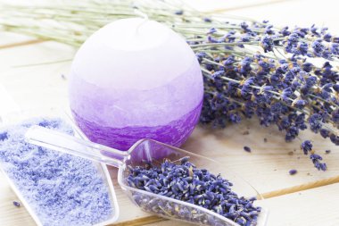 Lavanta çiçekleri ile spa ve sağlıklı yaşam ayarı, deniz tuzu, şişede yağ, ahşap beyaz arka plan üzerinde aroma mum
