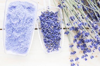 Lavanta çiçekleri ile spa ve sağlıklı yaşam ayarı, deniz tuzu, şişede yağ, ahşap beyaz arka plan üzerinde aroma mum