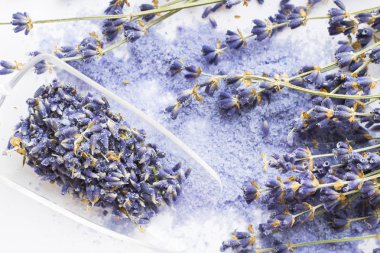 Lavanta çiçekleri ile spa ve sağlıklı yaşam ayarı, deniz tuzu, şişede yağ, ahşap beyaz arka plan üzerinde aroma mum