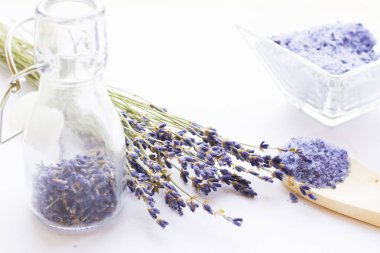 Lavanta çiçekleri ile spa ve sağlıklı yaşam ayarı, deniz tuzu, şişede yağ, ahşap beyaz arka plan üzerinde aroma mum