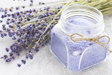 Lavanta çiçekleri ile spa ve sağlıklı yaşam ayarı, deniz tuzu, şişede yağ, ahşap beyaz arka plan üzerinde aroma mum