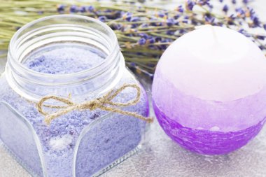 Lavanta çiçekleri ile spa ve sağlıklı yaşam ayarı, deniz tuzu, şişede yağ, ahşap beyaz arka plan üzerinde aroma mum