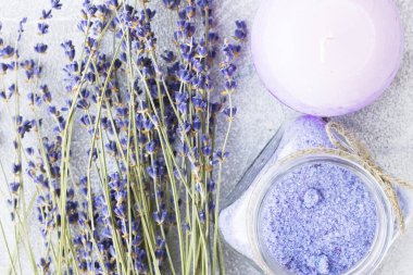 Lavanta çiçekleri ile spa ve sağlıklı yaşam ayarı, deniz tuzu, şişede yağ, ahşap beyaz arka plan üzerinde aroma mum