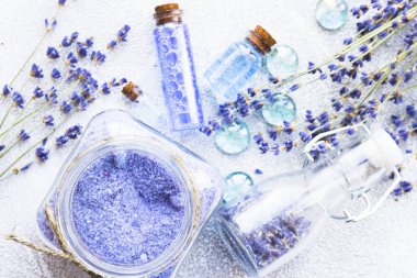 Lavanta çiçekleri ile spa ve sağlıklı yaşam ayarı, deniz tuzu, şişede yağ, ahşap beyaz arka plan üzerinde aroma mum