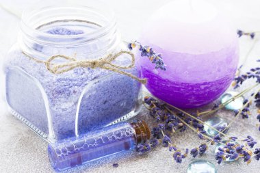 Lavanta çiçekleri ile spa ve sağlıklı yaşam ayarı, deniz tuzu, şişede yağ, ahşap beyaz arka plan üzerinde aroma mum
