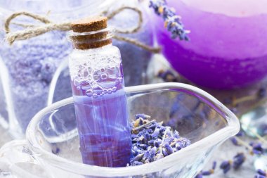 Lavanta çiçekleri ile spa ve sağlıklı yaşam ayarı, deniz tuzu, şişede yağ, ahşap beyaz arka plan üzerinde aroma mum