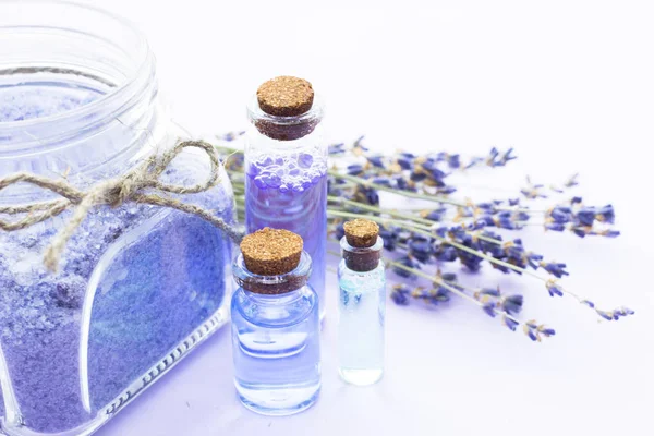 Lavanta çiçekleri ile spa ve sağlıklı yaşam ayarı, deniz tuzu, şişede yağ, ahşap beyaz arka plan üzerinde aroma mum — Stok fotoğraf