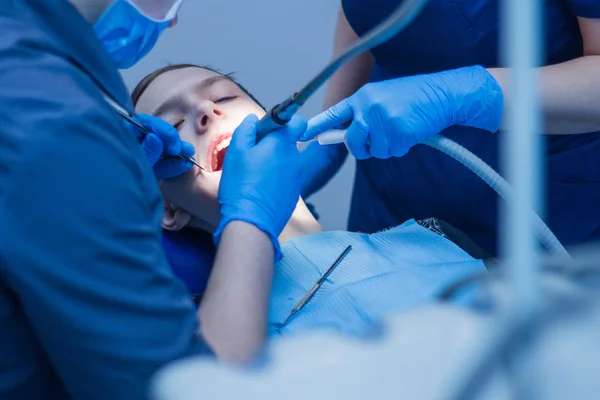 Een tiener met een open mond in de tandheelkunde bij de benoeming van een tandartsen. Tandheelkundige behandeling. — Stockfoto