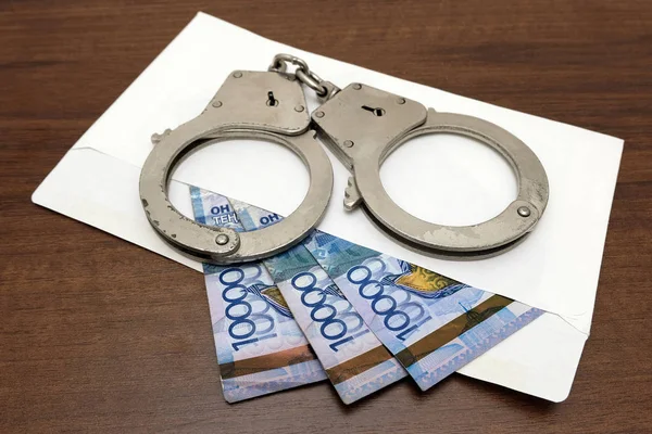 Kelepçeleri kazak para görüldü bir zarf üzerinde yalan. Otuz bin tenge rüşvet için hazırlanmış. Yolsuzluk ve Kazakistan'ın hukukun ihlali kavramı.