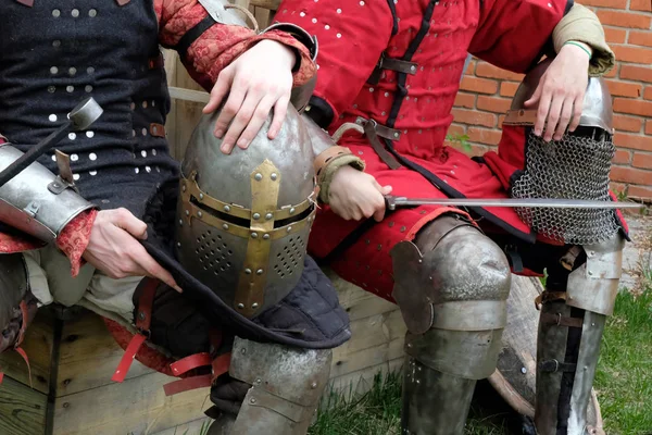 Zwei Männer in Ritterkleidung halten ihre Helme auf dem Schoß. — Stockfoto