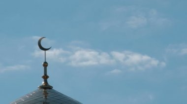 Kuş hilal yan tarafından Minare üzerinde uçar. Müslüman Camii üst hareket bulutlar bir close-up.