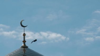 Üç gri güvercinler altın hilal minare üzerinde uçmak. Müslüman Camii üst hareket bulutlar bir close-up.