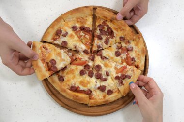 Pizza dilimleri ahşap plaka, alarak el görünümü kapatın
