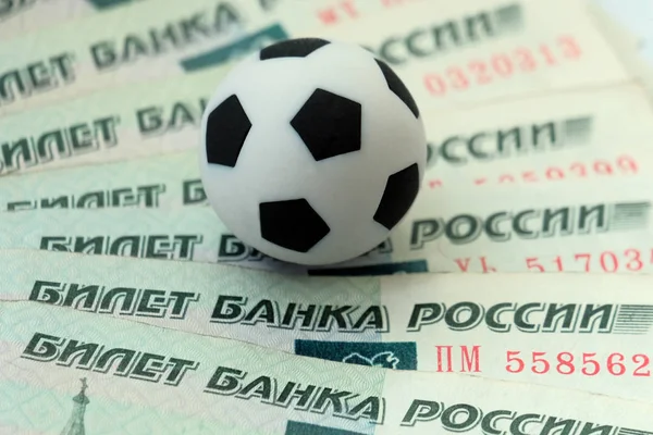 Rus ruble ve futbol topu. Yakın çekim. Kavramı maliyetleri ve gelirleri hayranları, oyuncu ve antrenörler, şampiyonluk için bahis spor.