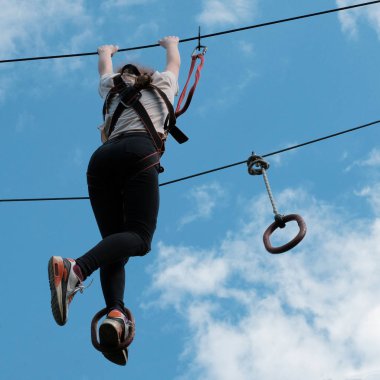 ZIP satırı aktivite. Macera Parkı'nda tırmanma zevk bir kız. Kare resim.