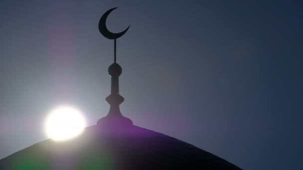 一个尖塔的剪影与一个穆斯林清真寺新月的背景下 太阳光线的早晨天空 — 图库视频影像