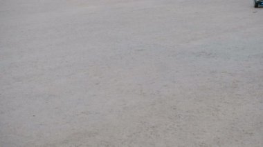 Genç bir kendi kendine karşı iki tekerlekli hoverboard asfalt üzerinde sürmek. Yakın çekim bacaklarım. Çerçevenin sağ alt sol üst köşesinde hareket.