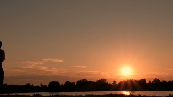 父亲和儿子在日出时在河堤上忙着晨跑 两个人沿着河岸或湖边奔跑的剪影 — 图库视频影像