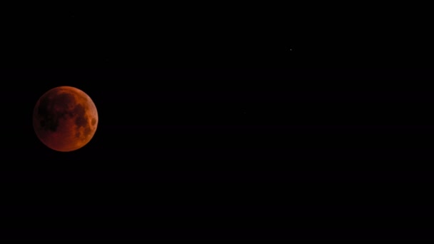 La pleine lune rouge sang traverse le ciel sombre, éclipse juillet 2018. L'ombre de la terre recouvre complètement le satellite naturel. Temps écoulé. Gros plan .