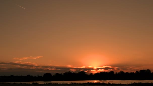 Amanecer. Una tira de un avión en el cielo. Adolescente con una camiseta blanca en bicicleta. Silueta de un niño ciclista . — Vídeos de Stock