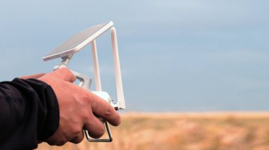 Beyaz Denetim Masası'ndan bir çiftçinin elinde insansız bir hava aracı. Video gözetimi, hava fotoğrafları ve video çekim radyo kontrollü uçaklar kullanarak kavramı. Kopya alanı.