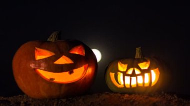 İki balkabağı içinde mumlar ile. Zaman sukut. Gece gökyüzü, dolunay. Tatil Cadılar Bayramı.