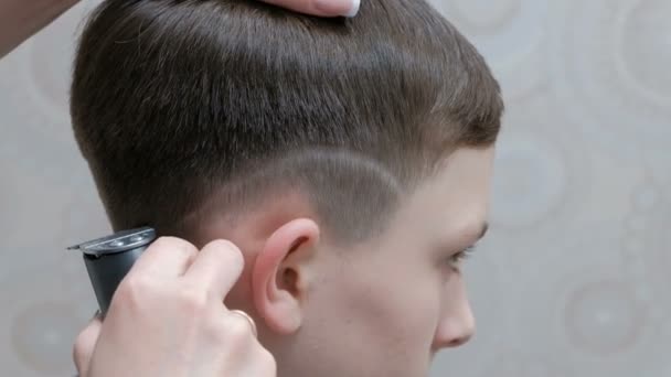 理发店里时髦的青少年发型 一个专业的男性理发师剃了一个小条在家伙的耳朵上方与一个理发剪 — 图库视频影像